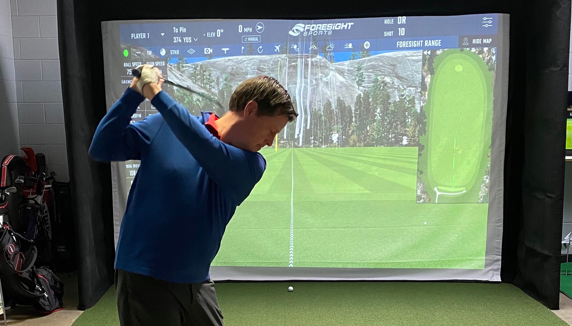 PlayBetter reviewer Marc swinging in an indoor golf simulator