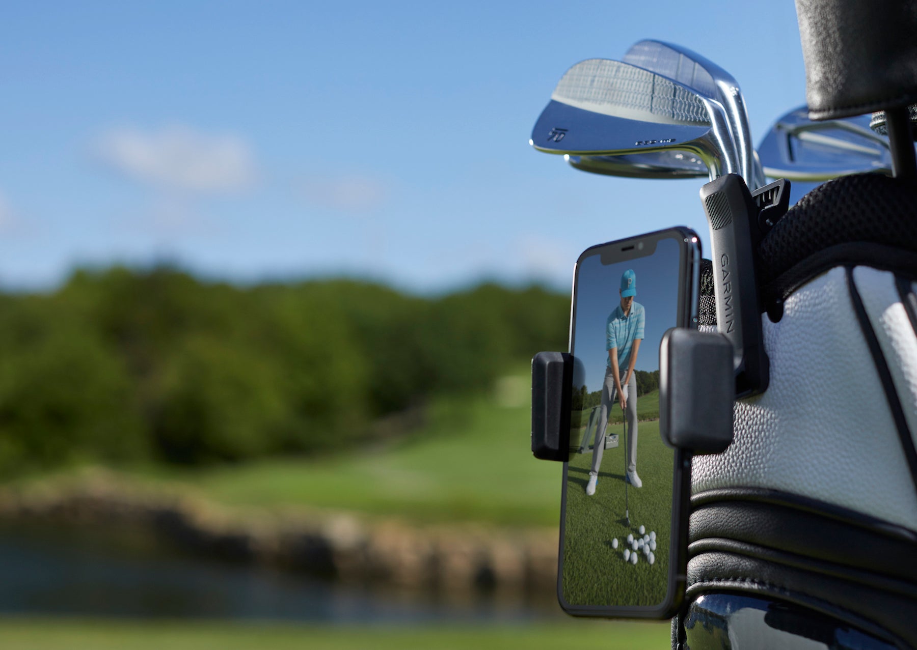 Golfer's swing video on a smartphone that is clupped to a golf bag.