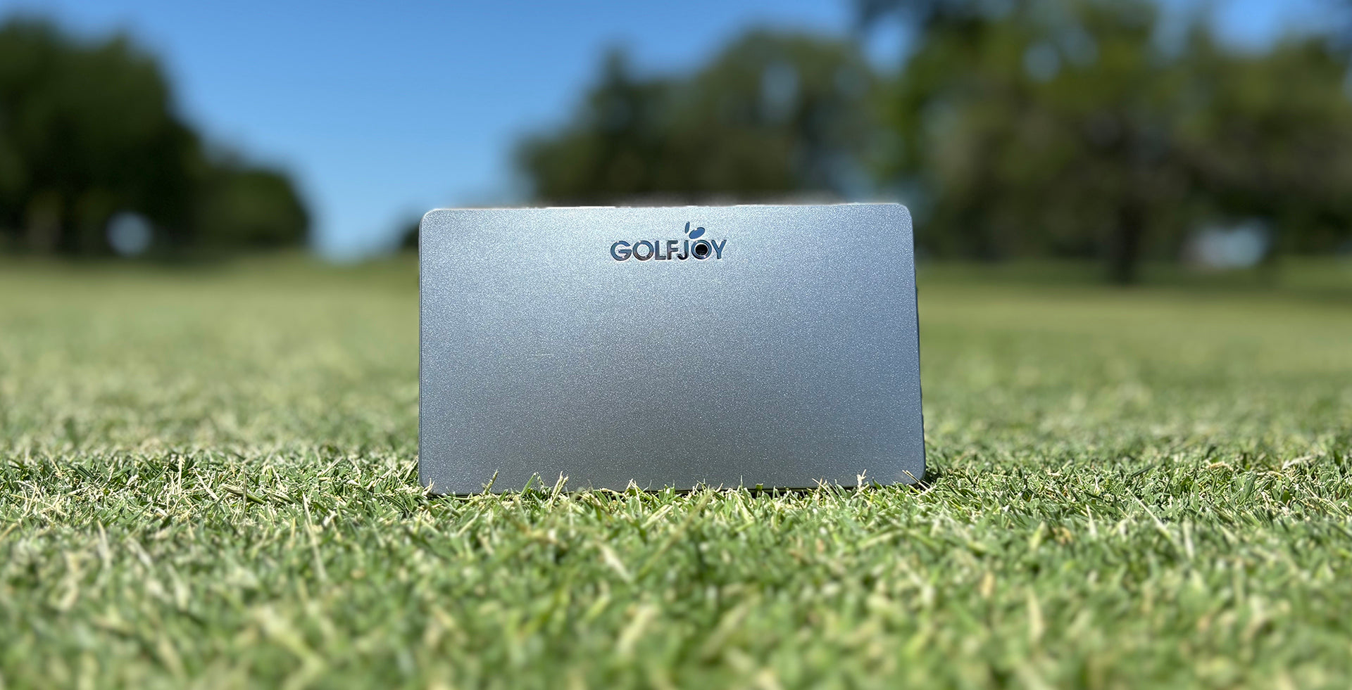 The Silver GolfJoy Golf Waver launch monitor sitting on the grass at the golf course (photo by PlayBetter golf reviewer Marc)