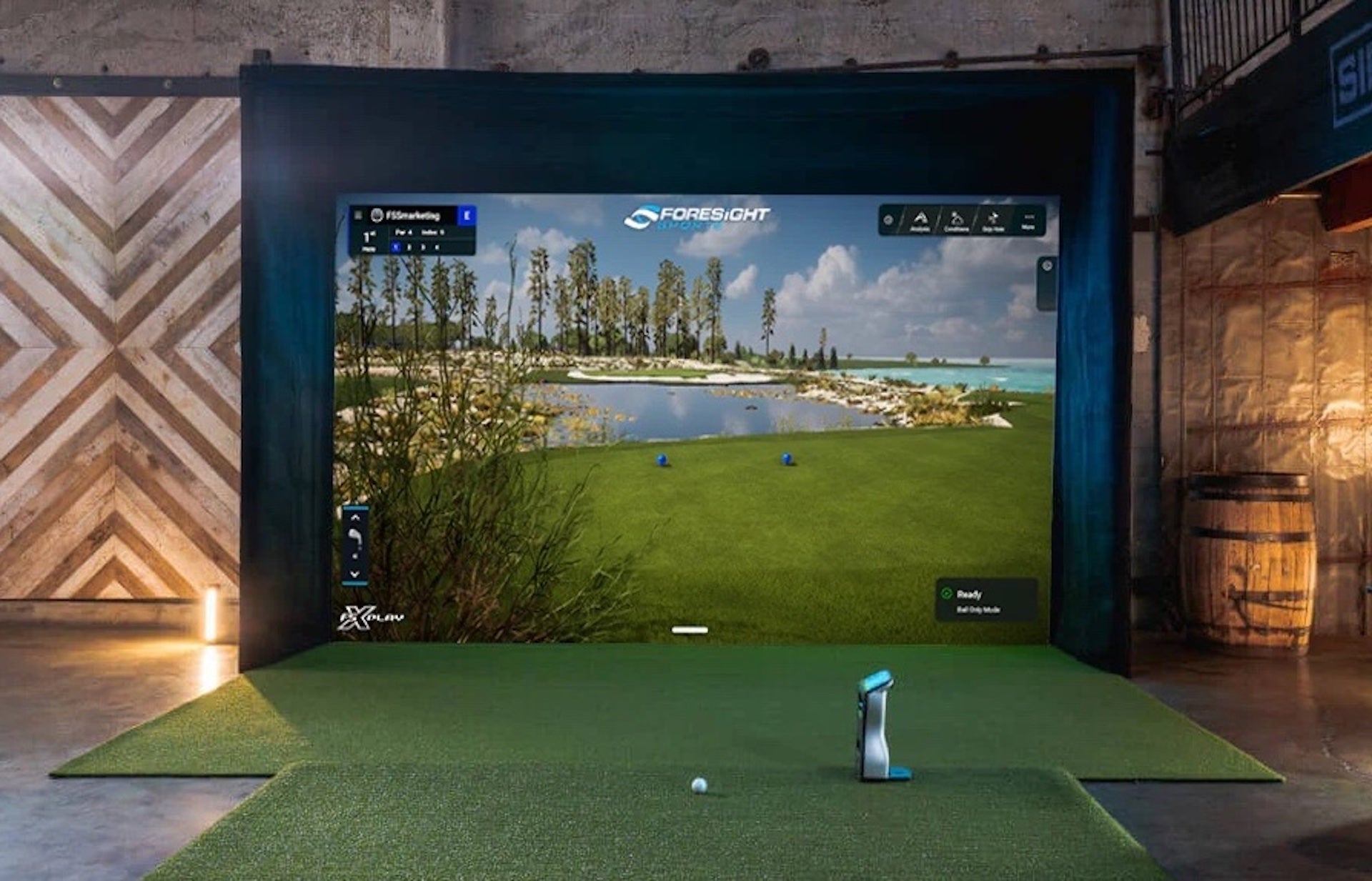 A Foresight Sports golf simulator with the QuadMAX launch monitor and a large impact screen and enclosure with Foresight virtual golf simulation software on it