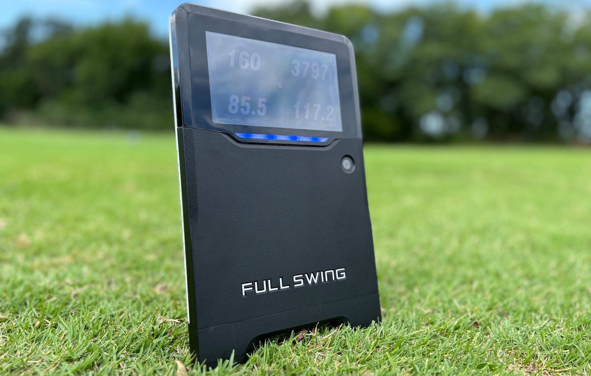 The Full Swing KIT golf launch monitor on the green grass on a bright day at the golf course (image by PlayBetter golf reviewer Marc) 