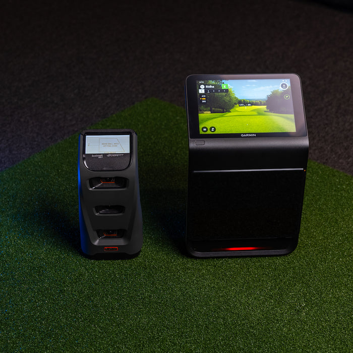 The Garmin Approach R50 next to the Bushnell Launch Pro golf launch monitor on a golf hitting mat