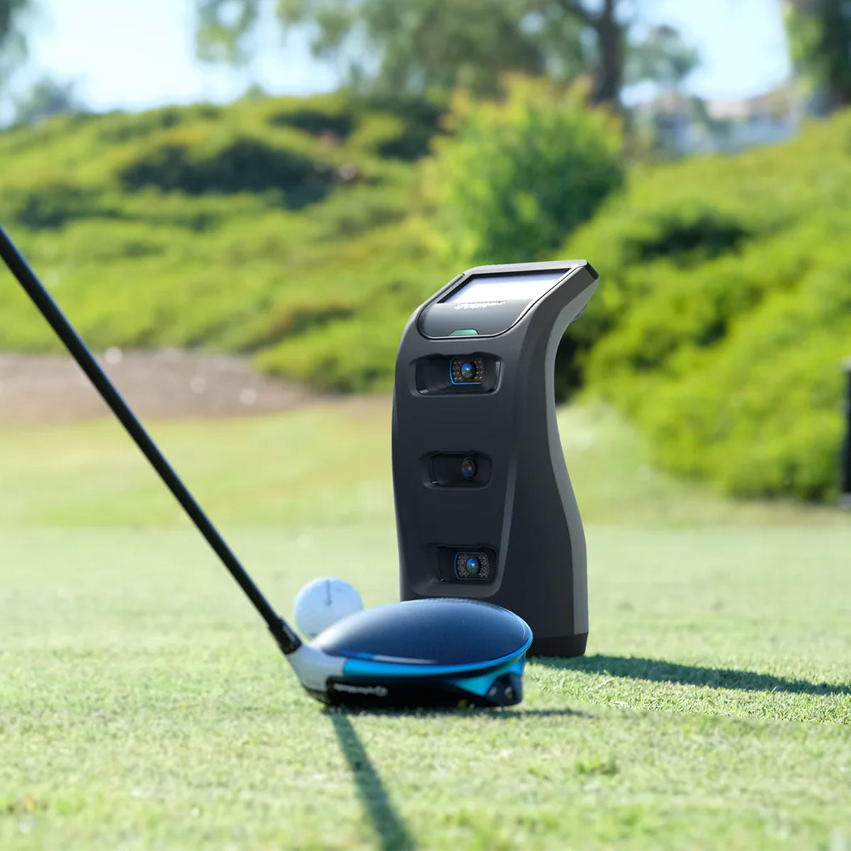 The Foresight Sports GC3 golf launch monitor on the golf course with a golf ball and golf driver head in front of it