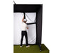 A man attaching the golf impact screen to the enclosure of the PlayBetter SimStudio golf simulator sitting on a golf hitting mat and landing turf